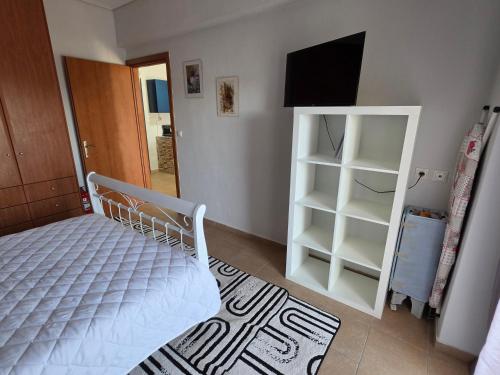 a bedroom with a bed and a tv and a mirror at Ippokratis 1 in Larisa