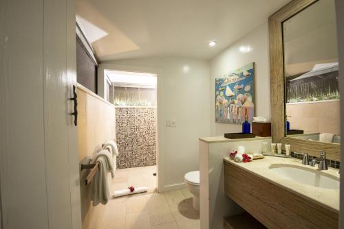 a bathroom with a sink and a toilet and a mirror at Tiamo Resort in Congo Town