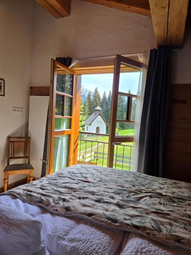 a bedroom with a bed and a large window at Eberlehof in Riezlern