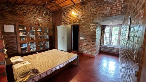 a room with a bed in a brick wall at Mutram Heritage Stay in Kanchipuram