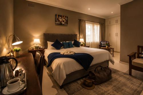 a bedroom with a large bed with blue pillows at Kentucky Hotel in Harare