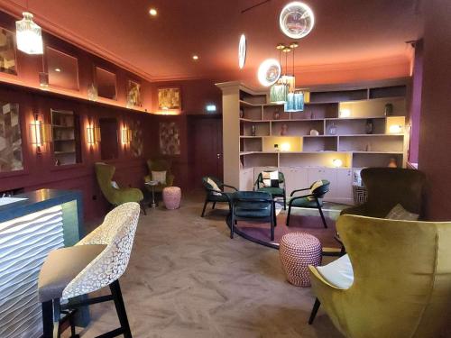 a waiting area with chairs and tables in a room at Mercure Moulins Centre Hôtel de Paris in Moulins