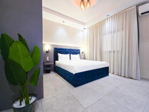 a bedroom with a bed and a potted plant at HOMETEL An Nahdah in Jeddah