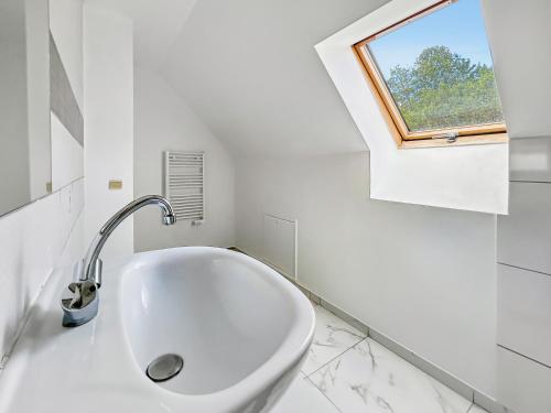 a white bathroom with a sink and a window at Maison rénovée 4 chambres, calme et convivialité in Mousseaux-lès-Bray