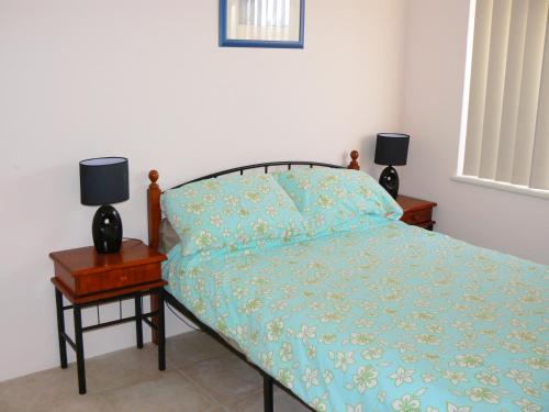1 dormitorio con 1 cama y 2 lámparas en una mesita de noche en Geraldton Luxury Vacation Home with free Streaming en Geraldton