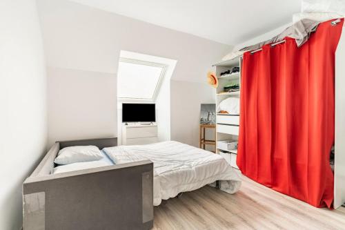 a bedroom with a bed with a red curtain at Petite maison chaleureuse avec une vue imprenable in Esson