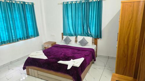 a bedroom with a purple bed with blue curtains at Blu Laguna Beach Homestay, Agatti Island, Lakshadweep - Only For Indian Nationals with valid entry permit in Agatti