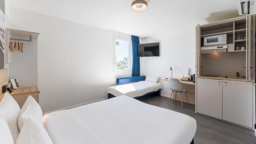 a hotel room with a bed and a desk at Campanile PRIME - Lyon Meyzieu Eurexpo Arena Stadium in Meyzieu