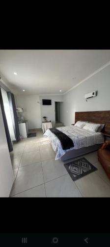 a bedroom with a large bed in a room at Nightingale Guesthouse Randfontein in Randfontein