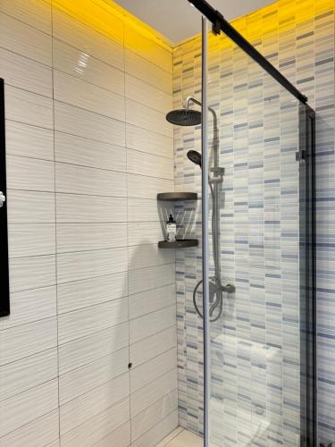 a shower with a glass door in a bathroom at Residence MBK Studio 1 in Ziguinchor