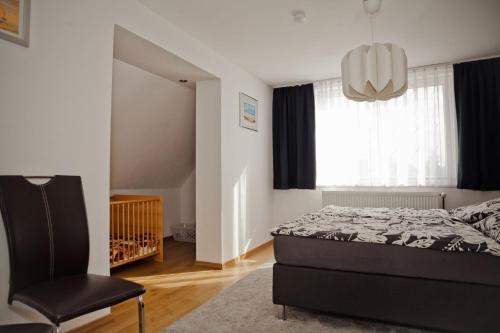 a bedroom with a bed and a chair and a window at Henning 2 in Kirchdorf