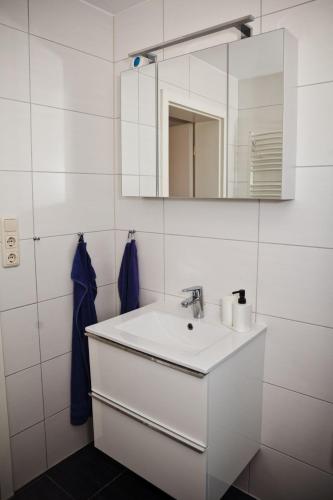 a white bathroom with a sink and a mirror at Henning 2 in Kirchdorf