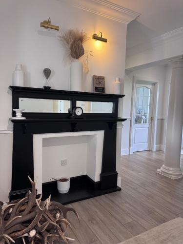 a fireplace in a living room with a black and white at Daviot Lodge in Inverness