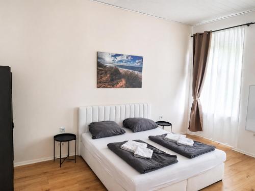 a white bed in a white room with two pillows at BaB Hotels and Apartments Apolo 3 in Chemnitz