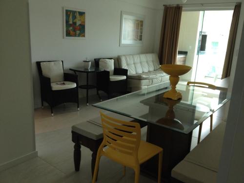 sala de estar con mesa, sillas y sofá en Atalanta I, en Bombinhas