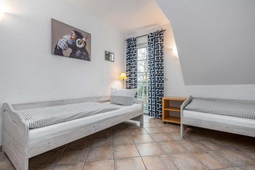 a bedroom with two beds and a window at Seestrasse Haus 15 in Zingst