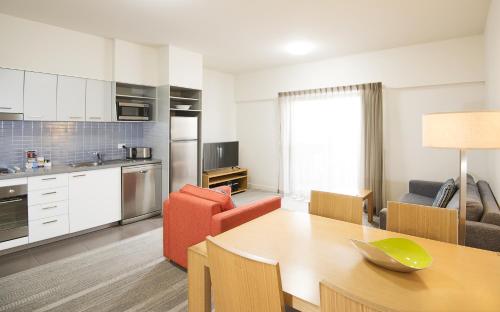 a kitchen with a table and chairs and a refrigerator at Aligned Corporate Residences Mackay in Mackay