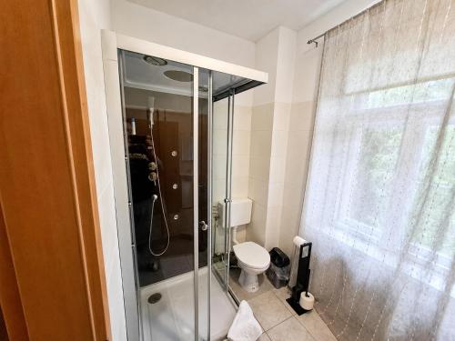 a bathroom with a toilet and a glass shower at BaB Hotels and Apartments Apolo 3 in Chemnitz