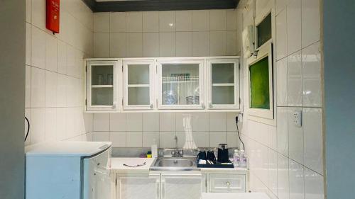 a kitchen with white cabinets and a sink at Al Raiyan Serviced Apartments in Taif