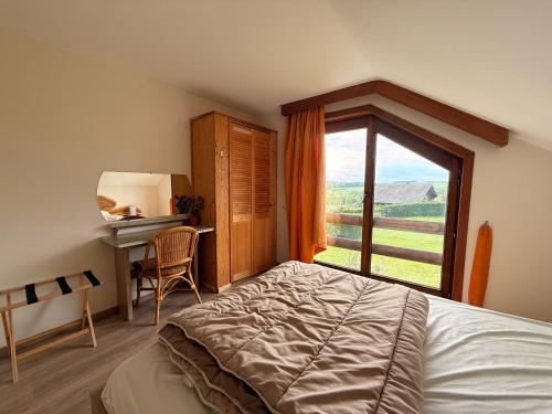 een slaapkamer met een bed en een groot raam bij Rotonde in Somme-Leuze