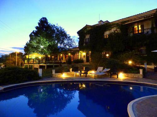 una piscina frente a una casa por la noche en Posada La Villa en Villa Carlos Paz