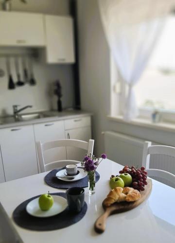 a kitchen table with a plate of fruit and bread at apartma Vila TARA in Prebold