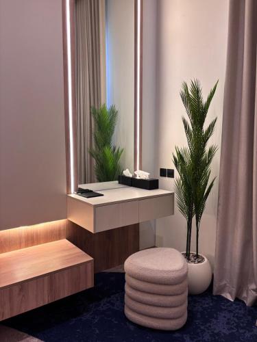 a bathroom with a vanity with a mirror and a plant at Voyage Expo Suites in Riyadh