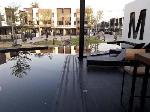 a building with a reflection of a tree in the water at New Loft Modern Home in Hang Dong