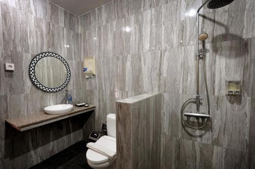 a bathroom with a shower and a toilet and a sink at The Nakula Villas in Legian
