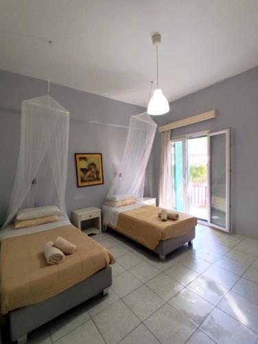 a bedroom with two beds and a large window at Maritsas Apartments in Roda