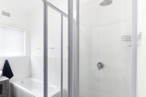 a white bathroom with a shower and a tub at Potties House in Arniston in Arniston