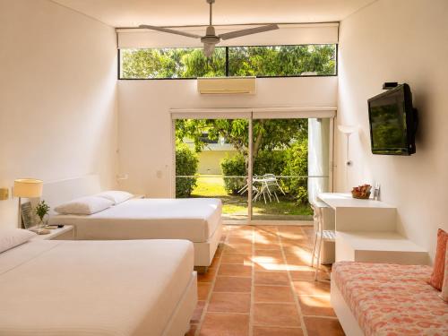 a hotel room with two beds and a television at La Masia Hotel Boutique in Anapoima