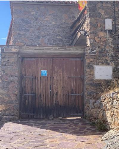 a wooden door on the side of a stone building at Casa Purujosa in Purujosa