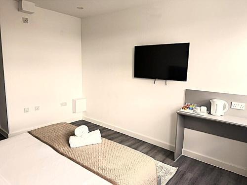 a room with a flat screen tv on the wall at Goodmayes Grand Hotel in Goodmayes