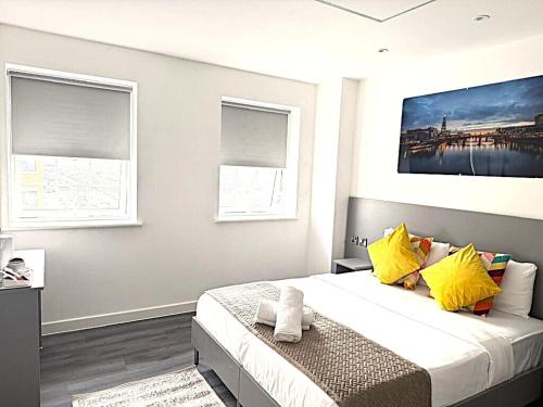 a bedroom with a large bed with yellow pillows at Goodmayes Grand Hotel in Goodmayes