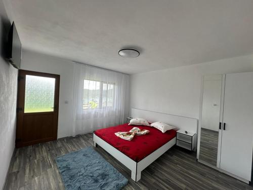 a bedroom with a bed with a red blanket at Casa De Vacanță Maga Dubova in Dubova