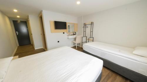 a hotel room with two beds and a desk at LEGEND TULIP HOTEL in Antalya