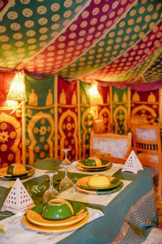 a table with plates and dishes on it in a room at Tente et Restaurant ElBey in Douz