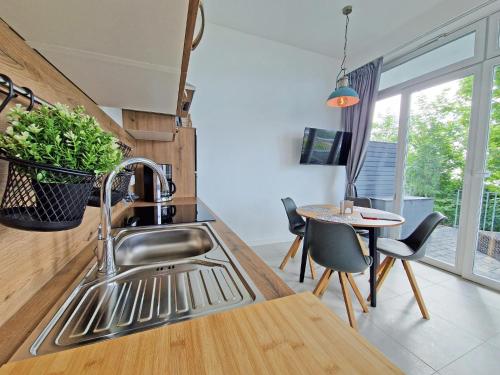 a kitchen with a sink and a table with chairs at Villa Küstenperle, Meerblick-Appartements in Sassnitz