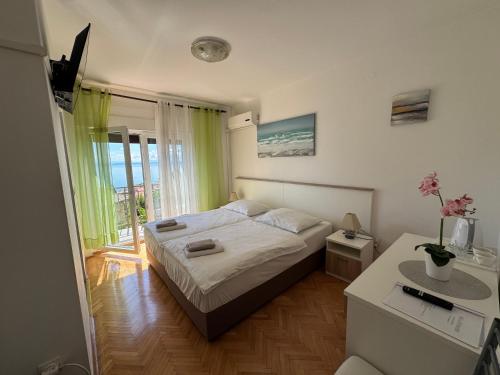 a bedroom with a bed and a desk and a window at Guesthouse Villa Stanger in Lovran