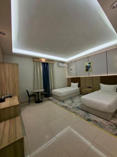 a large room with two beds and a table at راحتي ستار للشقق المخدومة in Ukaz