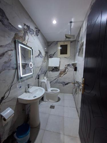 a bathroom with a sink and a toilet at راحتي ستار للشقق المخدومة in Ukaz