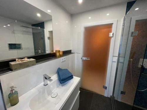 a bathroom with a sink and a shower with a mirror at Ferienwohnung Wildbichl in Sachrang in Sachrang