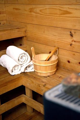 a wooden sauna with towels and a basket of towels at Nepalirika Hotel Biratchowk in Haraincha
