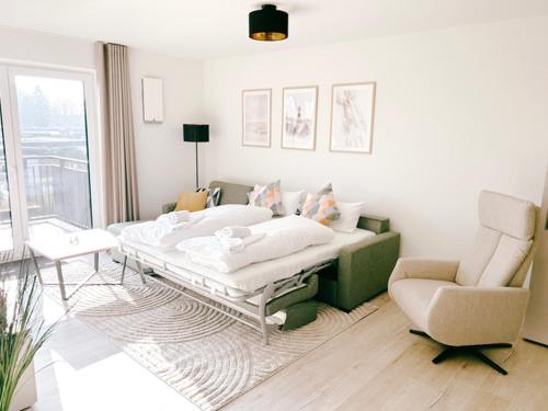 a bedroom with a bed and a couch and a chair at Küste33 34 in Tossens
