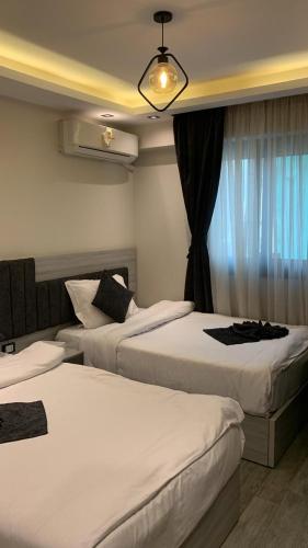 a hotel room with two beds and a window at Em banorama abrrtment hotel in Giza