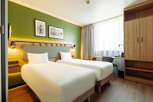 two beds in a hotel room with green walls at Campanile PRIME - Lodz in Łódź