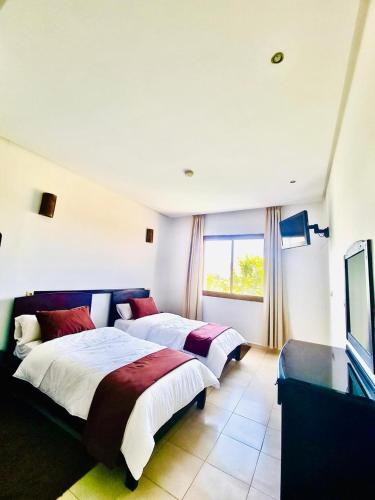 a hotel room with two beds and a television at Atlas Safari in Meknès