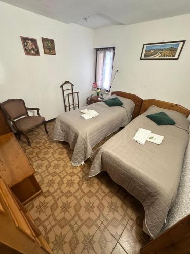 a room with two beds and a chair at Casa Voje in Serra Rocco