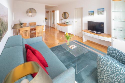 a living room with a blue couch and a table at Kleine Möwe 08 in Norderney